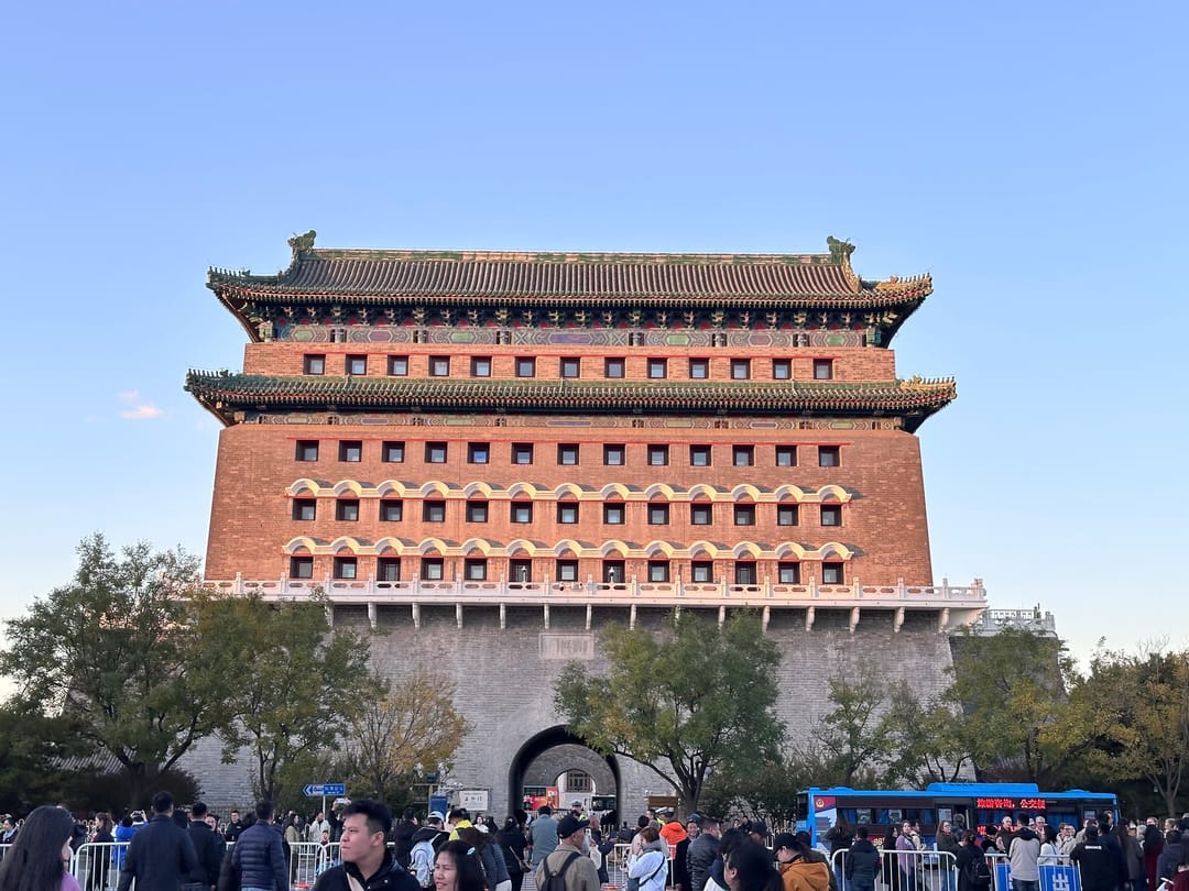 The red brick arrow tower of Zhengyangmen with rows of small windows, under a clear late-afternoon sky