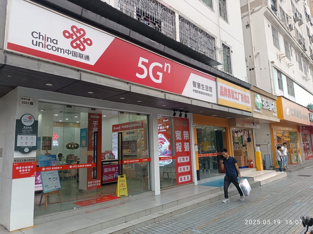 Filiale von China Unicom an der Binhe-Straße in Shenzhen, mit rotem Firmenschild und 5G-Werbung über dem Eingang