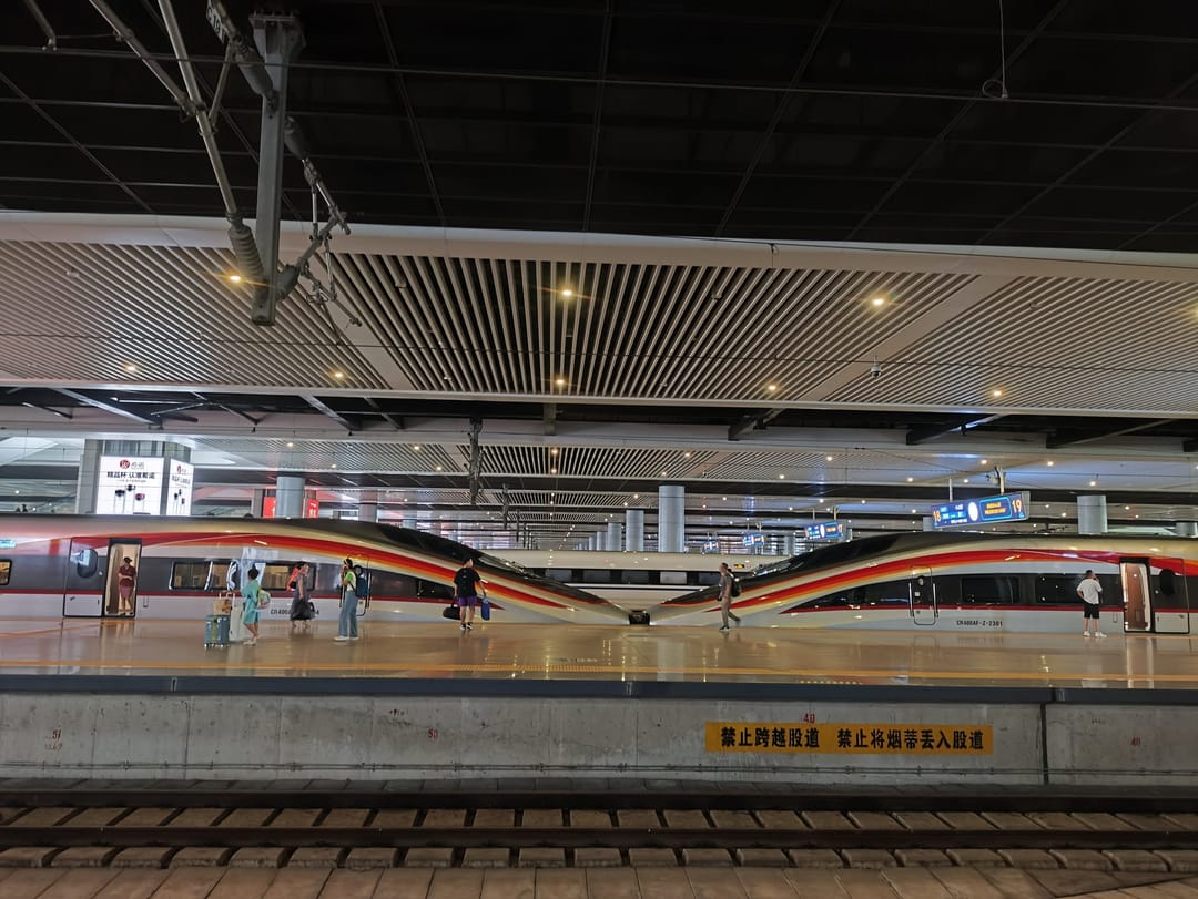 Dos trenes de alta velocidad Fuxing blancos con franjas rojas, acoplados morro con morro en un andén de Hangzhou Este