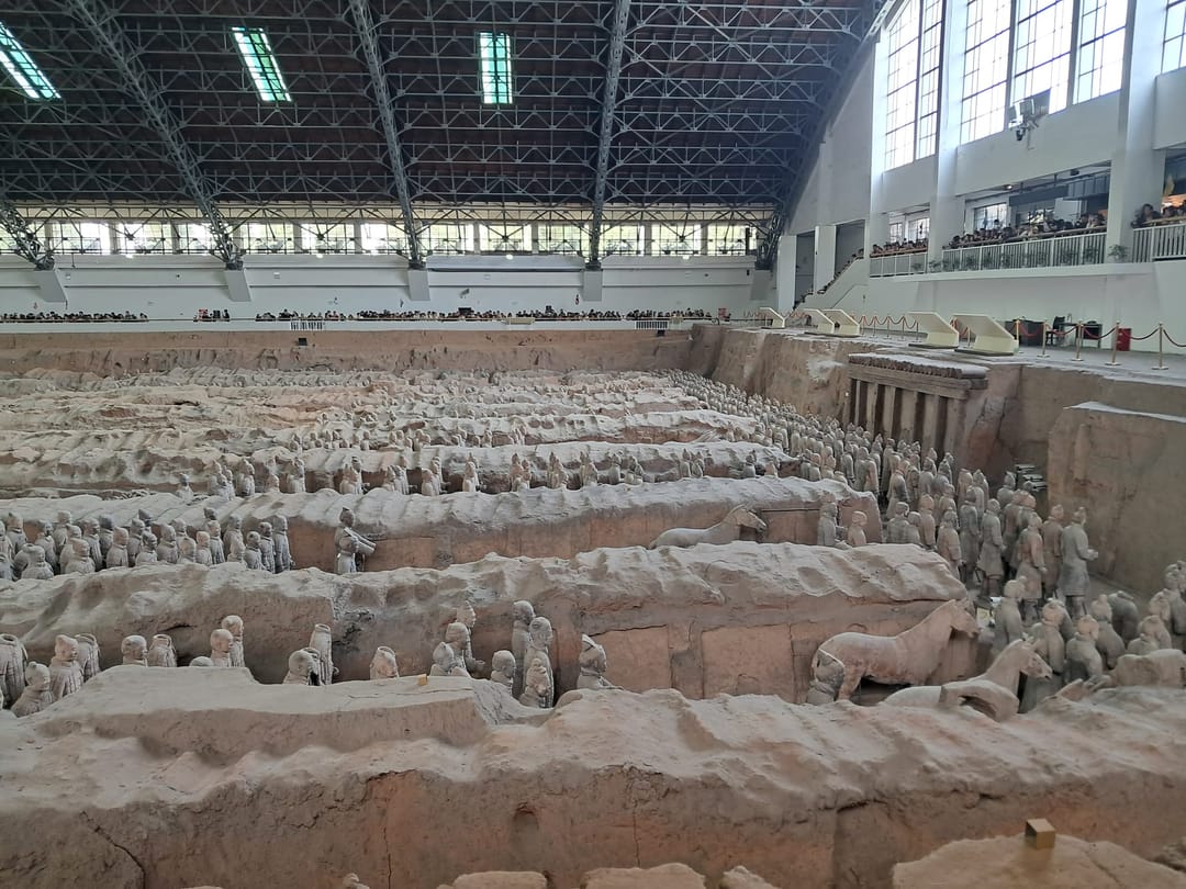 Filas de guerreros de terracota de pie en los pasillos de tierra de la fosa 1, bajo la gran cubierta del museo