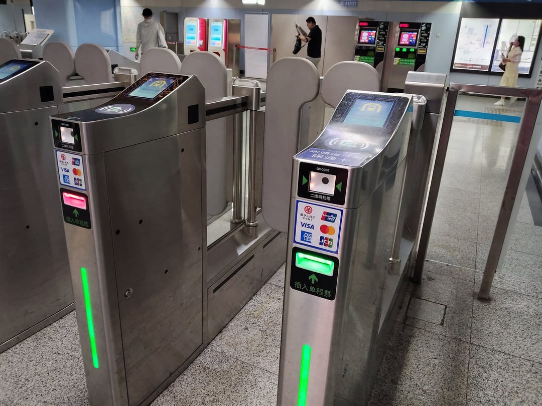 Shanghai metro gates with a QR reader and the logos of UnionPay, Visa, Mastercard, American Express and JCB