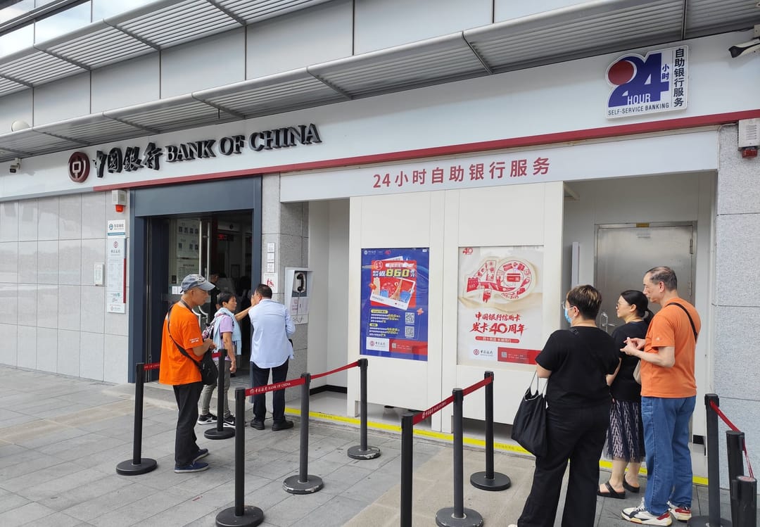 Kunden warten hinter Absperrbändern vor der 24-Stunden-Selbstbedienung der Bank of China am Grenzübergang Shenzhen Bay
