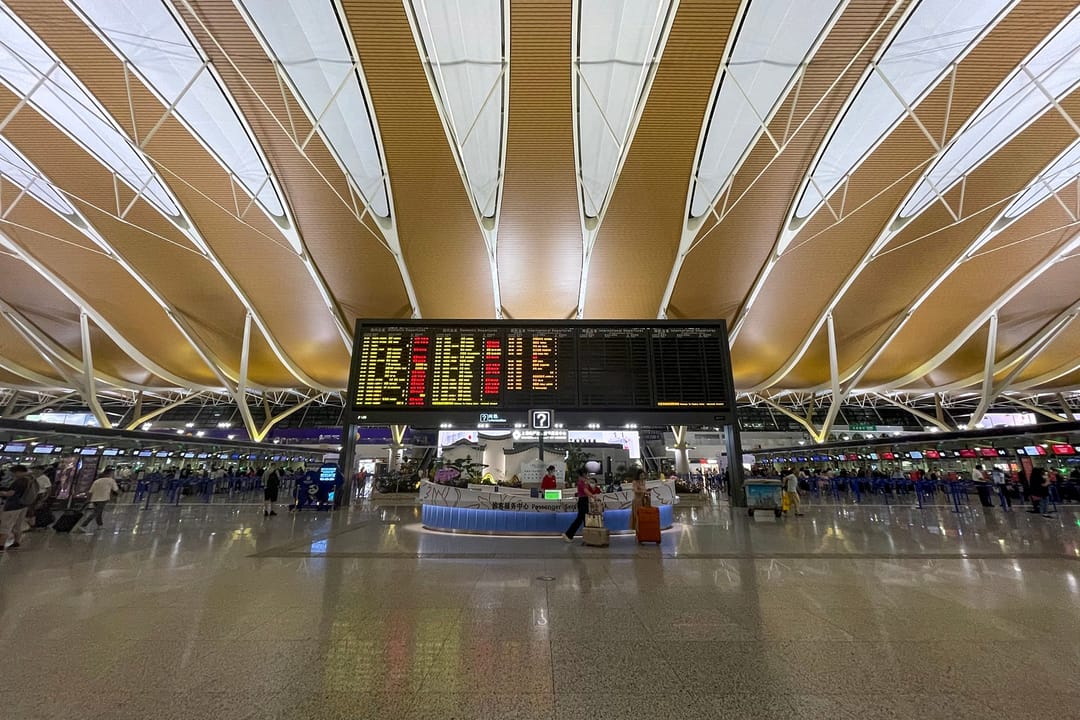 Abflughalle von Terminal 2 des Flughafens Shanghai Pudong mit Anzeigetafeln und Abfertigungsschaltern