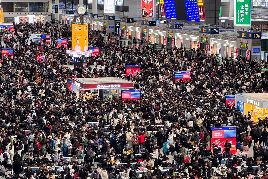 A dense crowd of travellers filling the departure hall of Shanghai Hongqiao railway station under its long roof