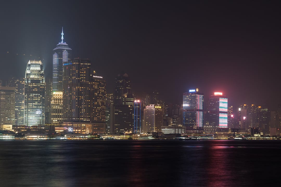 Las torres iluminadas de Central y Sheung Wan, en Hong Kong, reflejadas de noche en el puerto de Victoria desde Kowloon