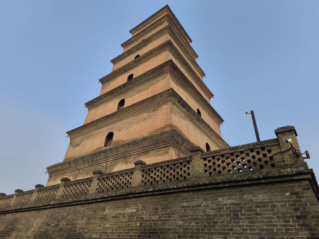 Los pisos cuadrados de ladrillo de la Gran Pagoda de la Oca Salvaje sobre una terraza con balaustrada y un cielo pálido